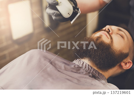 Barber styling beard with trimmer at barbershop, closeup. Stylish hairdresser in male hair salon Barber styling beard with trimmer at barbershop, closeup. Stylish hairdresser in male hair salon 137219601