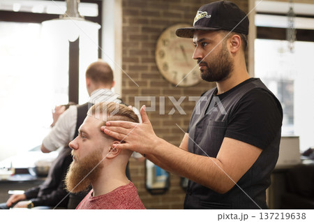 Styling hairdress to client. Male barbershop. Modern hairdresser in men hair salon Styling hairdress to client. Male barbershop. Modern hairdresser in men hair salon 137219638