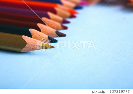 Wooden colorful pencils in row on blue background, close-up, objects, shallow depth of field Wooden colorful pencils in row on blue background, close-up, objects, shallow depth of field 137219777
