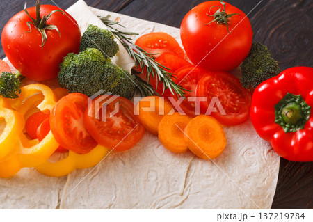 Cooking healthy vegetarian food background. Fresh organic vegetables on pita bread, natural food, close up. Cooking healthy vegetarian food background. Fresh organic vegetables on pita bread, natural food, close up. 137219784