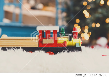 Wooden toy train on snowy decorated background. Selective focus, copy space 137219799