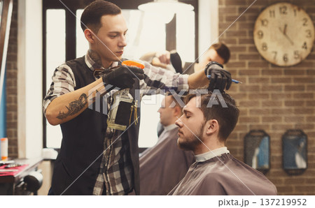 Spraying water, haircut in modern male barbershoip. Stylish barber and client 137219952