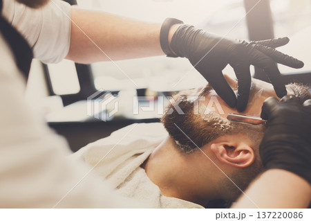 Barber styling beard with razor at barbershop, closeup. Stylish hairdresser in male hair salon Barber styling beard with razor at barbershop, closeup. Stylish hairdresser in male hair salon 137220086