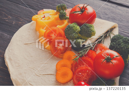 Cooking healthy vegetarian food background. Fresh organic vegetables on pita bread, natural food, close up. Cooking healthy vegetarian food background. Fresh organic vegetables on pita bread, natural food, close up. 137220135