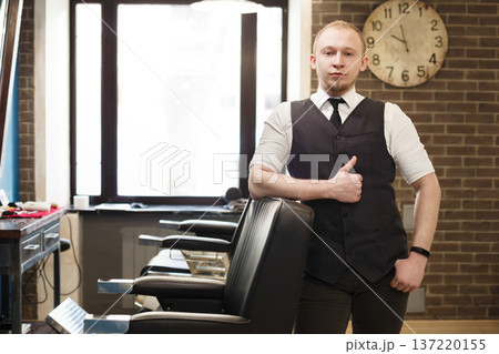Stylish barber wait for client. Young professional haitstylist in male barbershop Stylish barber wait for client. Young professional haitstylist in male barbershop 137220155