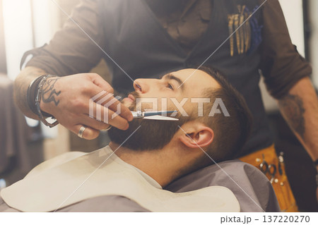Barber make beard haircut with scissors in barbershop, closeup of client's head. Hairstyle in male hair salon Barber make beard haircut with scissors in barbershop, closeup of client's head. Hairstyle in male hair salon 137220270