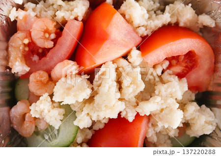 Healthy lunch in foil container. Healthy food take away and delivery, Rice, slices of tomato and cucumber, shrimps, closeup 137220288
