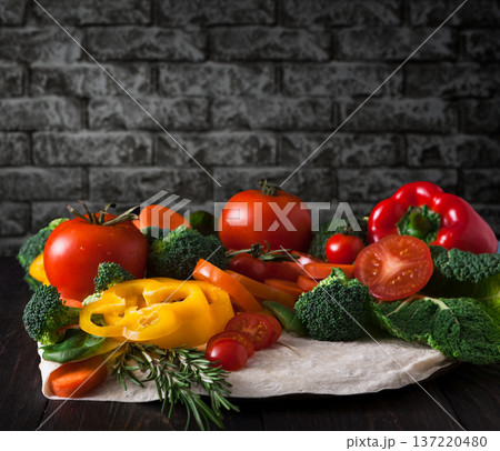 Cooking healthy vegetarian food on dark background. Fresh organic vegetables on pita flatbread. Natural food with copy space. 137220480