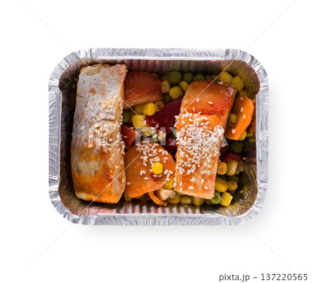 Healthy lunch in foil container. Healthy food take away and delivery. Red fish, corn, carrot, green pea and sesame in box on white background, closeup, isolated Healthy lunch in foil container. Healthy food take away and delivery. Red fish, corn, carrot, green pea and sesame in box on white background, closeup, isolated 137220565