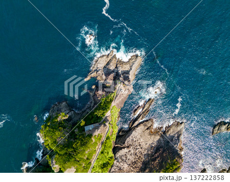 石廊崎オーシャンパークのドローン撮影。 白く美しい石廊崎灯台、岬の先端の断崖絶壁に石室神社がある。 137222858
