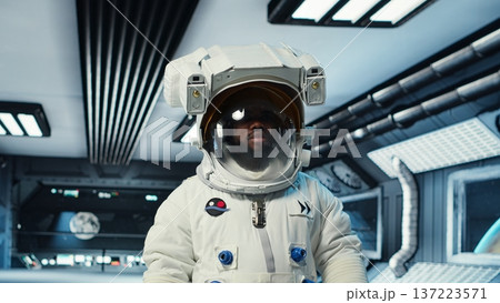 Scientist wearing helmet walking in cutting edge spaceship, doing cosmic voyage in solar system. African american astronaut wearing cosmonaut gear aboard orbital station, camera B Scientist wearing helmet walking in cutting edge spaceship, doing cosmic voyage in solar system. African american astronaut wearing cosmonaut gear aboard orbital station, camera B 137223571