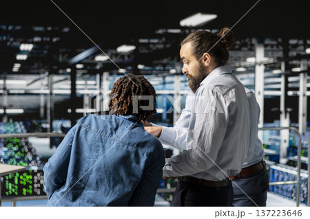 Concerned IT experts reacting to critical error notification on laptop, worrying about data breach in data center. Stressed employees attempting to resolve system fault for infrastructure. Concerned IT experts reacting to critical error notification on laptop, worrying about data breach in data center. Stressed employees attempting to resolve system fault for infrastructure. 137223646