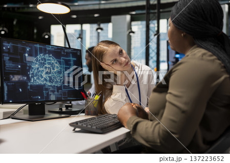 Sad young girl at work receives comforting support from caring AI tech startup coworker. Distressed junior developer gets help from senior colleague listening to her and giving advice 137223652