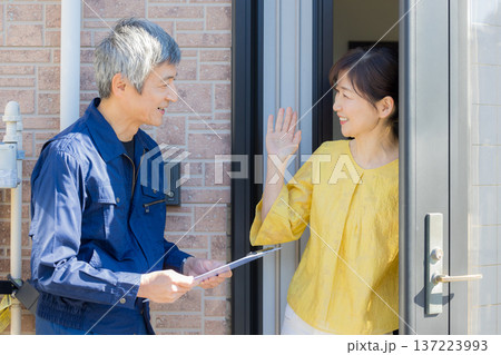 玄関で説明する作業服の男性 玄関で説明する作業服の男性 137223993