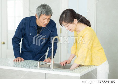 水回りの説明をする作業服の男性 137224105