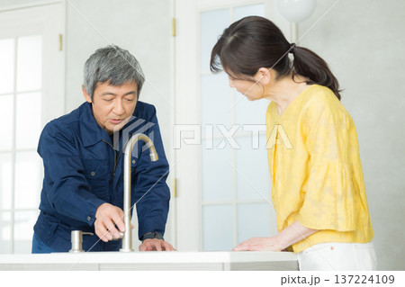 水回りの説明をする作業服の男性 137224109