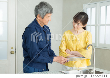 水回りの説明をする作業服の男性 水回りの説明をする作業服の男性 137224111