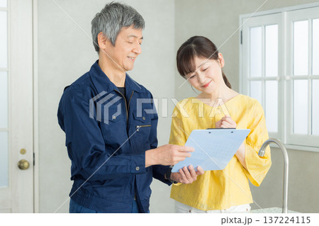 水回りの説明をする作業服の男性 水回りの説明をする作業服の男性 137224115