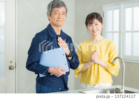 水回りの説明をする作業服の男性 137224117