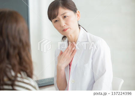 患者に説明する白衣の女性 患者に説明する白衣の女性 137224396