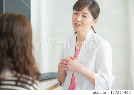 患者に説明する白衣の女性 137224400