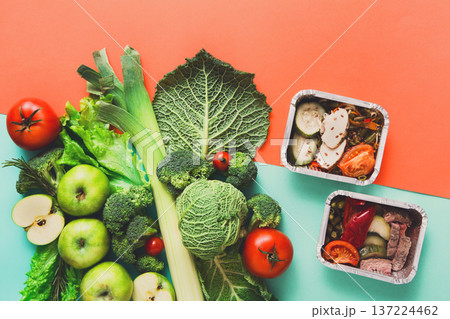 Healthy meals in lunch boxes with green vegetables and fruits. Diet, detox and healthy food concept - top view flat lay on bright background. Ingredients for salad Healthy meals in lunch boxes with green vegetables and fruits. Diet, detox and healthy food concept - top view flat lay on bright background. Ingredients for salad 137224462