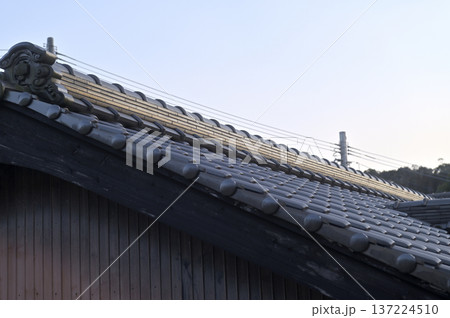青空に映える日本の伝統的な瓦屋根と鬼瓦の意匠1 137224510