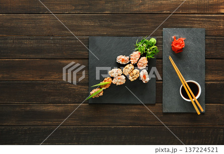 Japanese food restaurant, sushi gunkan roll plate, platter set. Creative food. Set with chopsticks, ginger, soy, wasabi. Sushi at rustic wood background and black stone. Flat lay, top view. Copyspace. Japanese food restaurant, sushi gunkan roll plate, platter set. Creative food. Set with chopsticks, ginger, soy, wasabi. Sushi at rustic wood background and black stone. Flat lay, top view. Copyspace. 137224521