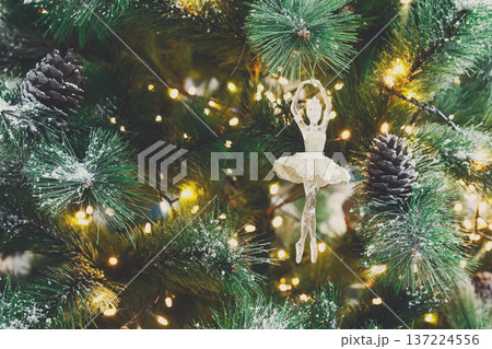 Christmas tree holiday background. Xmas magic and beauty. Fluffy pine tree branches with pinecones, sprinkled with snow and decorated with shiny garland, closeup Christmas tree holiday background. Xmas magic and beauty. Fluffy pine tree branches with pinecones, sprinkled with snow and decorated with shiny garland, closeup 137224556