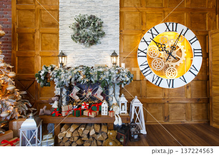 Beautiful holdiay living room. Fireplace decorated with fir tree wreath and garland. Winter holiday design and decorations background 137224563