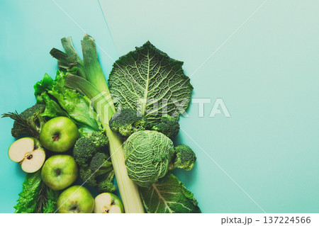 Green vegetables and fruits. Diet, detox and healthy food concept - top view flat lay of vegetarian meals on bright blue background. Ingredients for salad 137224566
