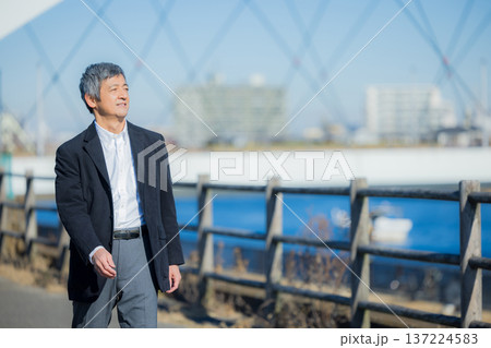 河川敷を歩く男性 137224583