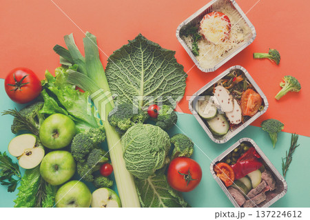 Healthy meals in lunch boxes with green vegetables and fruits. Diet, detox and healthy food concept - top view flat lay on bright background. Ingredients for salad 137224612