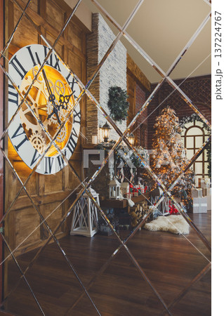 Beautiful holdiay living room with lots of presents under decorated christmas tree, fireplace and huge clock reflecting in mirror. Winter holiday design and decorations background 137224767