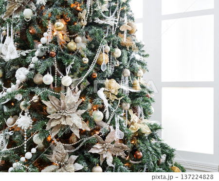 Christmas magic background. Beautiful decorated xmas tree in white living room. Shining lights, balls, baubles and garland. Winter holidays magic atmosphere. Modern design and decorations, copy space Christmas magic background. Beautiful decorated xmas tree in white living room. Shining lights, balls, baubles and garland. Winter holidays magic atmosphere. Modern design and decorations, copy space 137224828