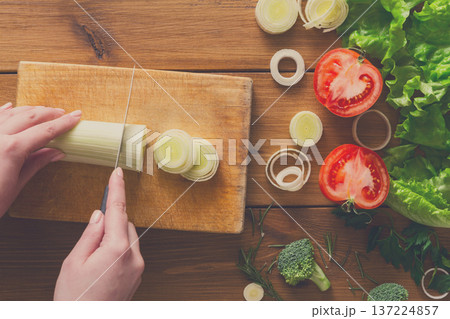 Cooking healthy food background. Cutting leek, fresh organic vegetables on wood. Natural food with copy space. Cooking healthy food background. Cutting leek, fresh organic vegetables on wood. Natural food with copy space. 137224857