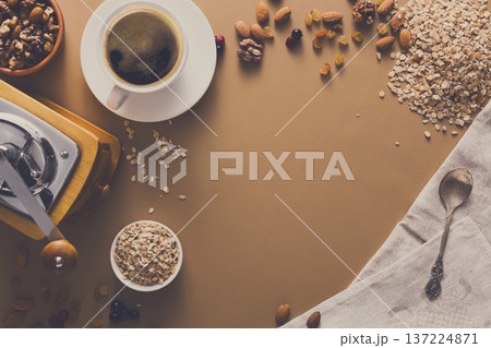 Flat lay of breakfast meal - cup of coffee, oat and nuts on beige table background. Still life, copy space, Mockup, template. 137224871