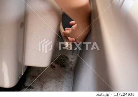 ベランダ・バルコニーに設置されたエアコン室外機のドレンホースからのドレン排水 137224939