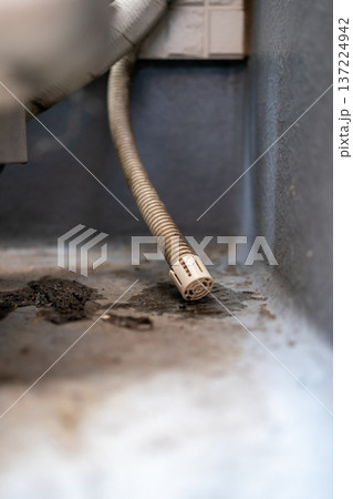 ベランダ・バルコニーに設置されたエアコン室外機のドレンホースの先につけられたキャップ 137224942