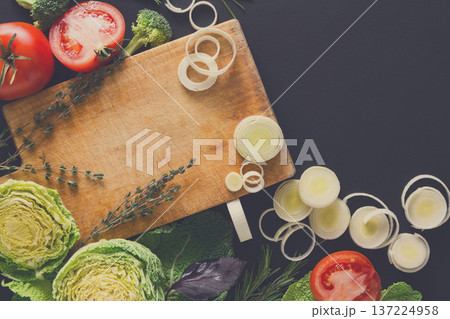 Healthy cooking background. Cutting leek and other vegetables. Fresh organic food on black with copy space. Healthy cooking background. Cutting leek and other vegetables. Fresh organic food on black with copy space. 137224958