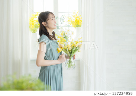 窓辺に花を飾る女性 137224959