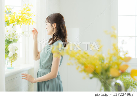 窓辺に花を飾る女性 137224968