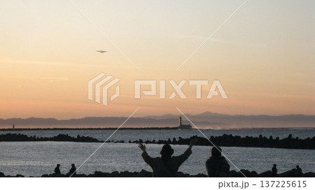 夕焼け空と佐渡島と日本海とジェットフォイルと飛行機 137225615