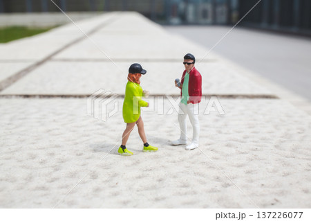 Miniature figures engage in conversation on raised outdoor platform Miniature figures engage in conversation on raised outdoor platform 137226077