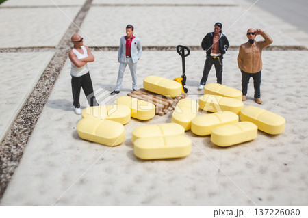 Miniature workers gather around scattered yellow cargo pieces Miniature workers gather around scattered yellow cargo pieces 137226080
