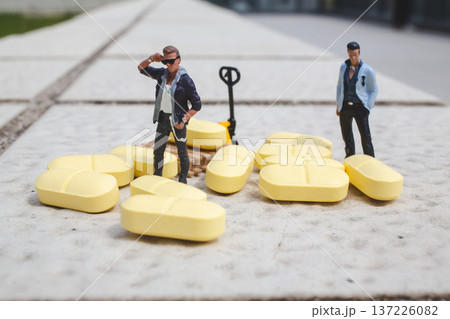 Miniature workers gather around scattered yellow cargo pieces Miniature workers gather around scattered yellow cargo pieces 137226082