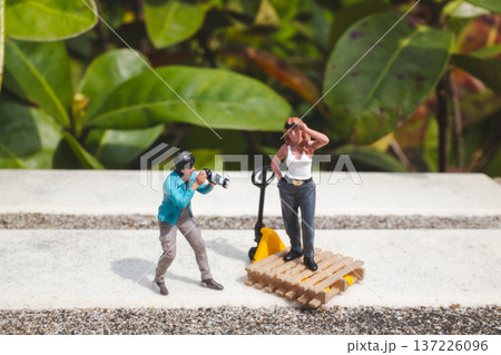 Miniature photographer captures model posing confidently on platform Miniature photographer captures model posing confidently on platform 137226096