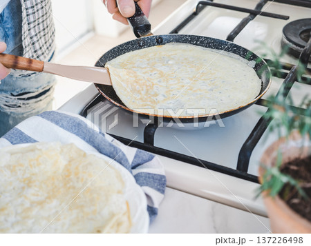 Man's hands flip a thin pancake Man's hands flip a thin pancake 137226498