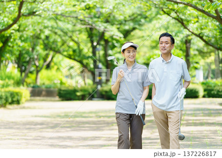 ゴルフをするシニア夫婦 137226817
