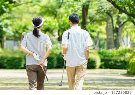 ゴルフをするシニア夫婦の後姿 ゴルフをするシニア夫婦の後姿 137226829